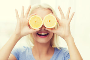 woman holding lemons infront of her eyes - eye health